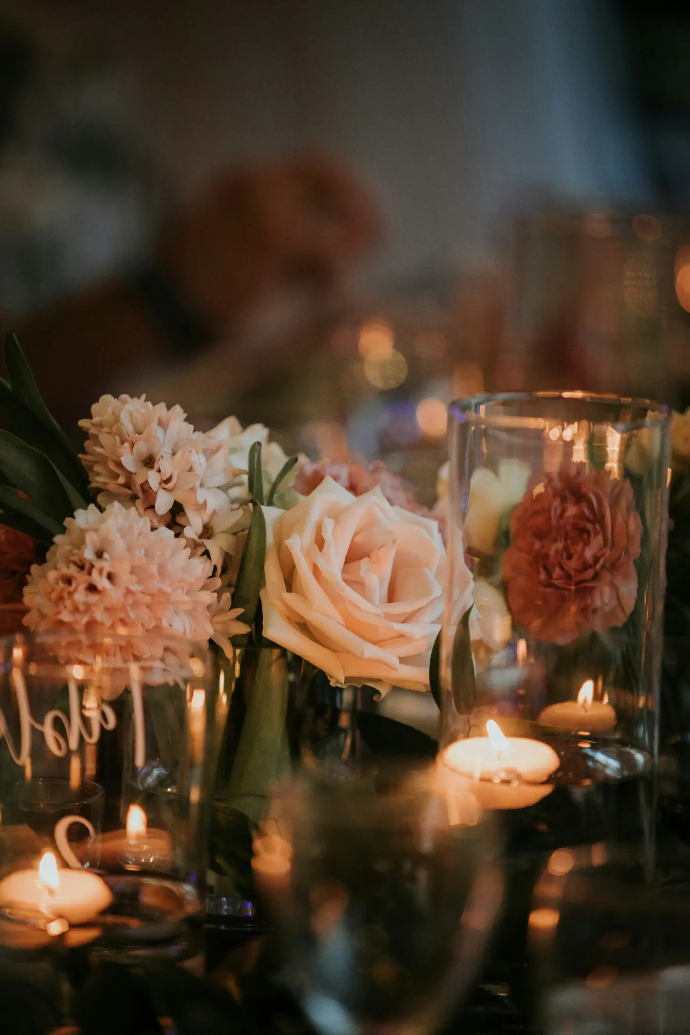 A wedding table by candlelight, with blush roses and tea lights.